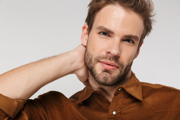 Fototapeta premium Portrait of unshaven young man posing and looking at camera