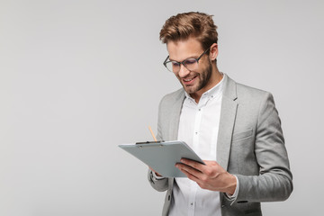 Portrait of happy young man in eyeglasses holding clipboard and smiling