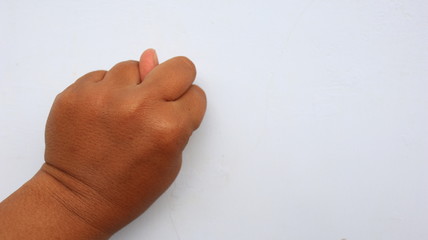 left hand photographed with the meaning of a symbol and white background, not in focus. blurry