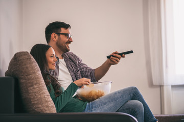 Couple is relaxing at home. They are watching tv.