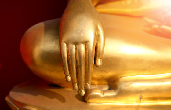 gold bhuddha statue close up hand