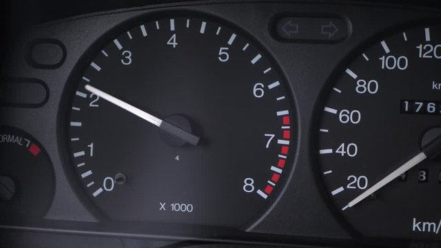 Tachometer on car dashboard during engine ignition at the old car