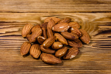 Heap of the peeled almond nuts on wooden table