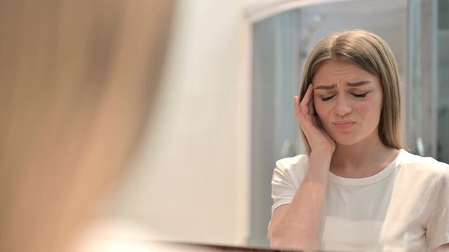 Rear View of Attractive Woman Looking in Mirror and having Headache 