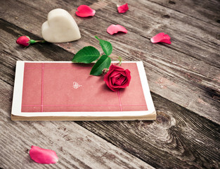 Flowers. Red roses with Book, Heart and Petals on wooden table. Vintage Valentine Floral background. Toned image in retro style.