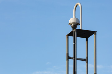The video surveillance camera is mounted on a metal support. Copy space