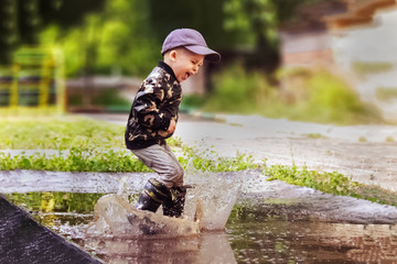 child jumping in a puddle after rain
