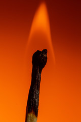 Burned match in the coals and fire on Lush Lava background. close up copy space