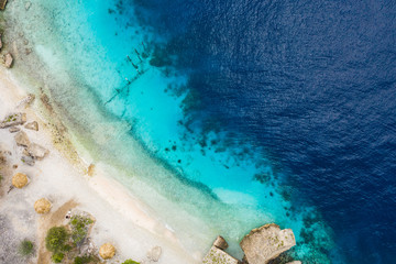 Aerial view of coast of Curaçao in the Caribbean Sea with turquoise water, cliff, beach and beautiful coral reef over Director's bay
