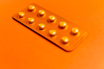 Orange pack of tablets on orange background