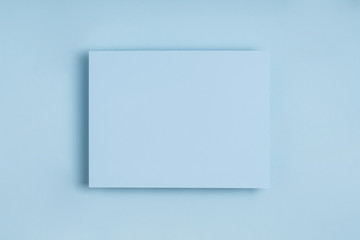 Minimal frame geometric composition mock up. Blank sheet of paper postcard on delicate blue.