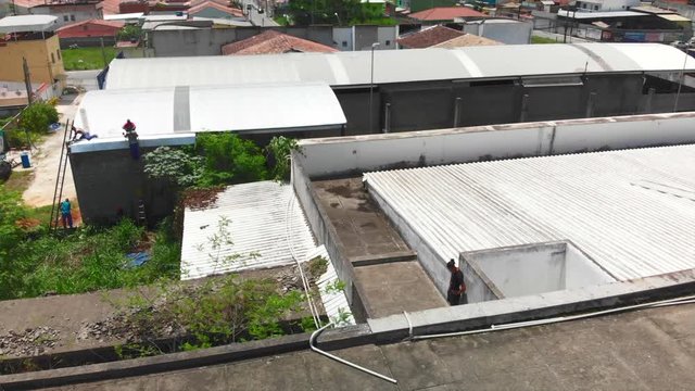 two young freeruners jumping and performing  flips and tricks over obstacles on a rooftop followed bya drone