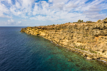 Aerial view of coast of Curaçao in the Caribbean Sea with turquoise water, cliff, beach and beautiful coral reef over Caracas Bay