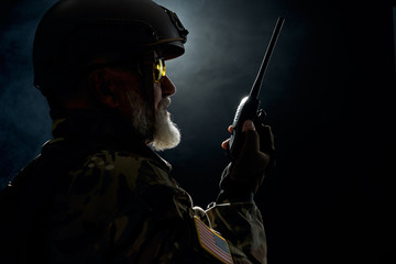 Old military commander holding radio station.