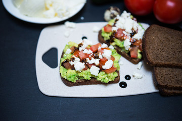 Avocado Sandwich with Cheese and Tomato. Rye Toast with White Soft Cheese, Avocado and Tomatoes Poured Balsamic Sauce for Healthy Breakfast or Snack