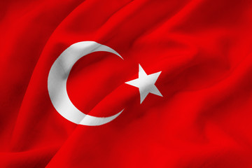 Turkish national flag waving in the wind. A closeup of the red silk standard of the Republic of Turkey with a white crescent and a white star. Turkey colors background.