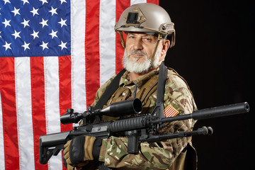 Old military officer holding sniper rifle.