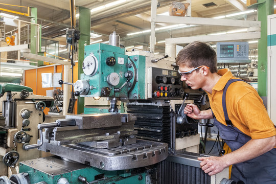 A trainee in the metalworking industry works on a milling machine