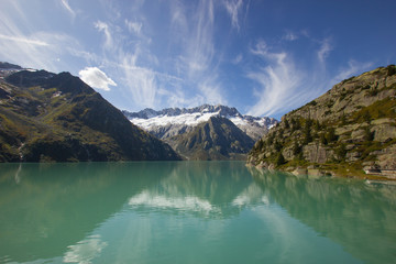 beautiful lake on the Goescheneralp with snow covered mountains in the background