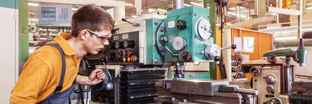 A trainee in the metalworking industry works on a milling machine