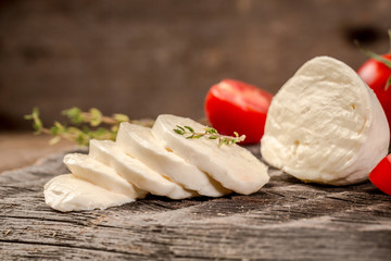 Mozzarella cheese, basil and tomato cherry on slate stone board, copy space. Ingredients for Caprese salad. Free space for your text