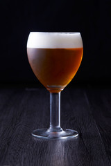 Brown beer texture standing at black background.