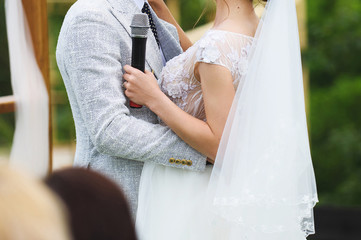 Fototapeta na wymiar hugging newlyweds with microphone