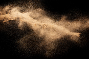 Brown dry river sand explosion isolated on black background. Abstract sand splash. - obrazy, fototapety, plakaty