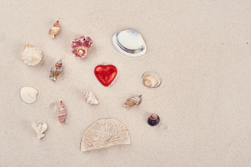 Fototapeta na wymiar Chocolate red praline hearts on the beach sand on St. Valentine's Day