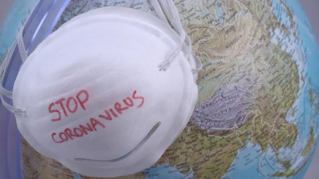 Novel coronavirus - 2019-nCoV, WUHAN virus concept. Surgical mask protective mask with CORONAVIRUS text and globe world                