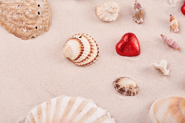 Chocolate red praline hearts on the beach sand on St. Valentine's Day