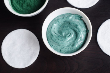 Green (blue) bentonite clay and yogurt mask in the bowl. Diy facial mask and body wrap recipe. Close up, top view.