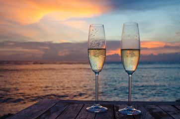 Glasses with wine on a sunset background