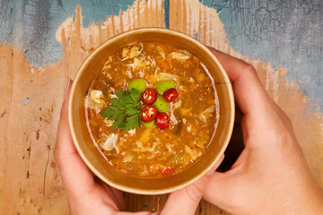 Woman holding hot and sour soup in eco cup.