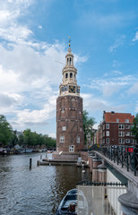 View of Montelbaanstoren tower in Amsterdam, Netherlands. Former fortification to protect the city on bank of the Oudeschans.