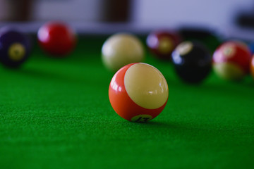 Pool table with pool balls of various colours.