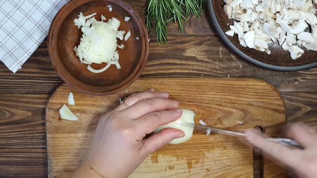 Slicing ingredients for a rice dish with vegetables. Vegetarian dish. Mushrooms and carrots onions. Healthy diet. On a wooden background.