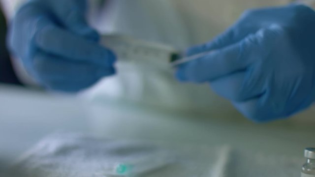 Nurse inserts syringe needle for injection