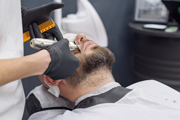 Fototapeta premium beard modeling in Barber shop, beard care for men, male beauty concept
