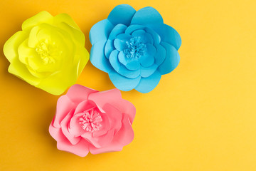yellow background with three big colorful flowers from paper