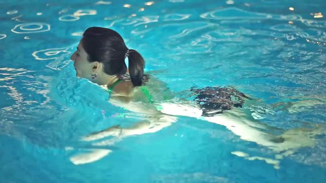 Girl, breaststroke swimming in pool
