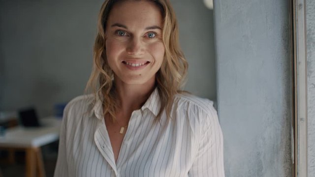 Positive dropshipping business entrepreneur removing her spectacles and smiling. Caucasian businesswoman looking happy.