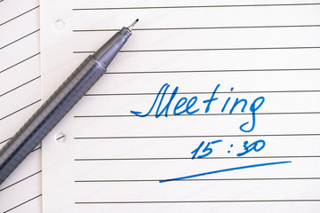 Handwriting text Meeting 15 30 on lined paper with pen.
