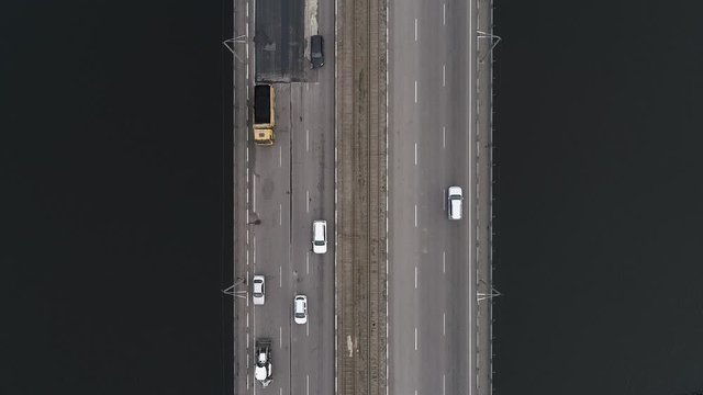 Cars ride on two bridges over the river. The camera is directed downwards rises to a greater height and rotates. Aerial panoramic top view flying sky footage Shooting with a drone.