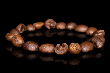 Lot of whole fresh coffee bean circle isolated on black glass