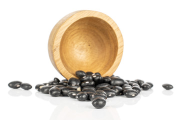 Lot of whole black bean in bamboo bowl isolated on white background