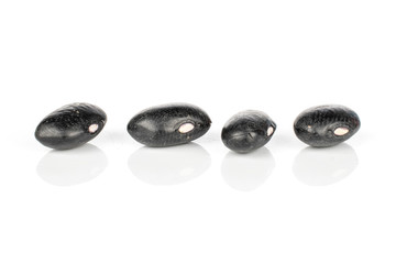 Group of four whole black bean isolated on white background