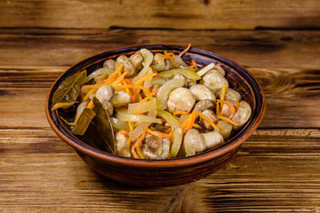 Canned mushrooms with carrot and onion in a ceramic bowl