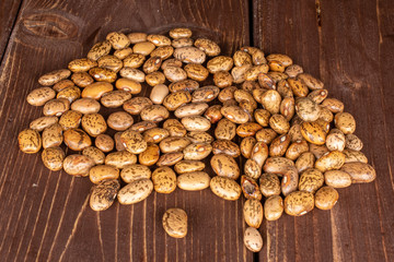 Lot of whole mottled brown bean pinto on brown wood