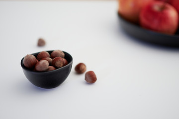 Hazelnuts and apples on a white background